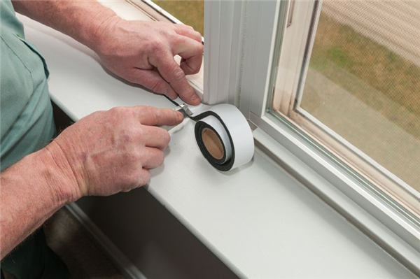 Insulation_tape A man applying insulation tape to a window